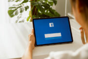 Bangkok, Thailand - May 11, 2020 : Woman hand holding digital tablet and pressing the Facebook screen on apple ipad, Social media are using for information sharing and networking.